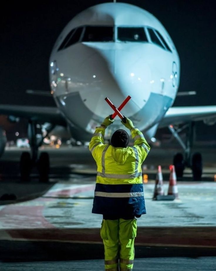Ground marshaller guiding a freighter aircraft at night